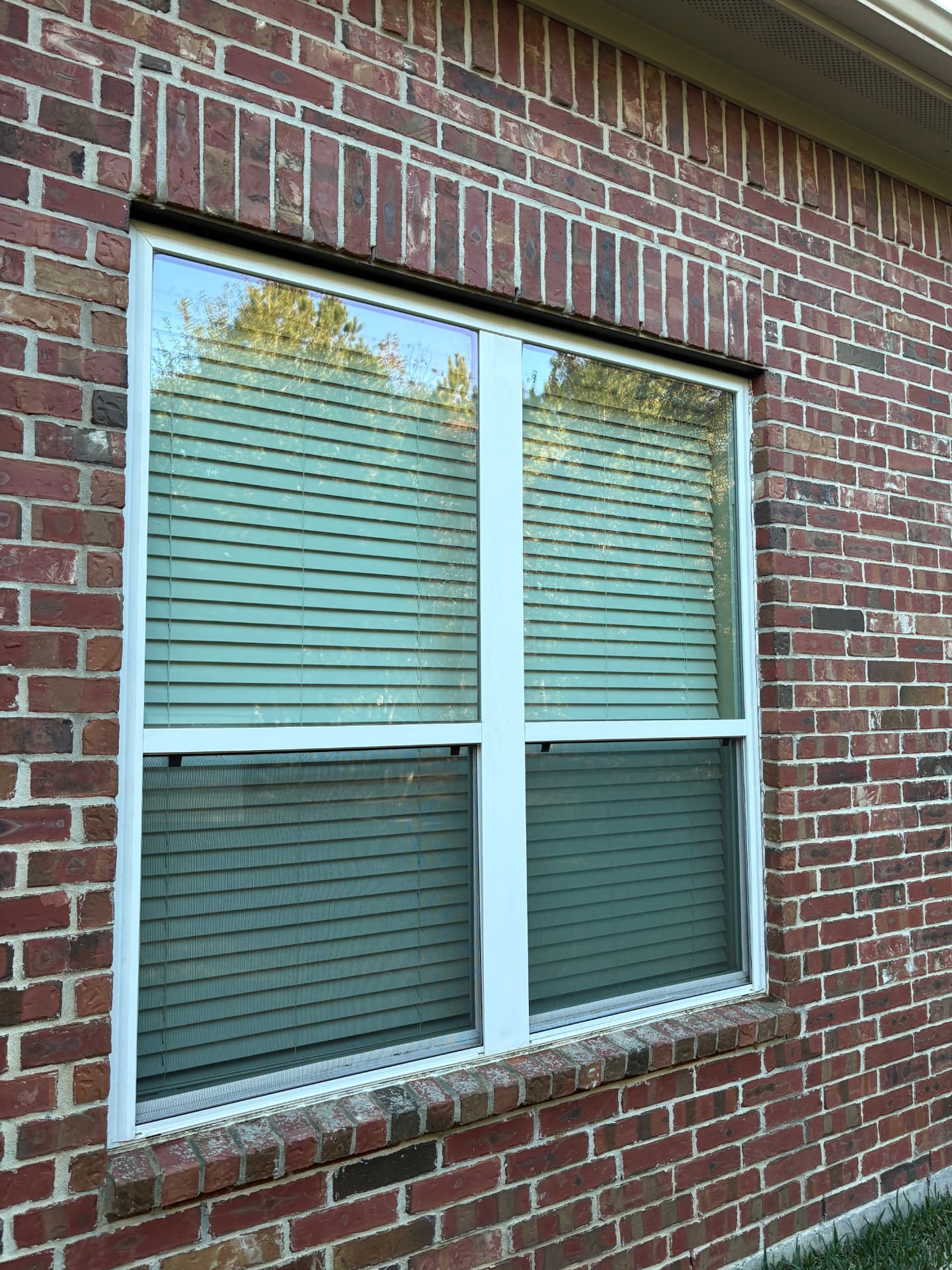 Window on a red brick wall after a clean — pressure washing in Montgomery, TX