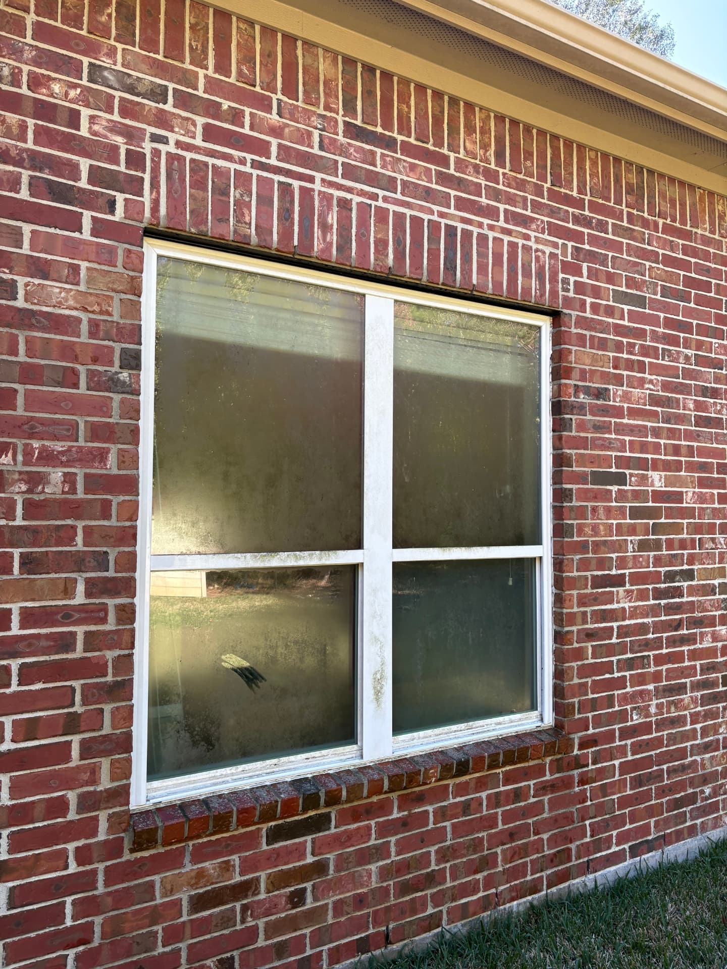 Windows covered in dirt on a brick home — pressure washing in Montgomery, TX